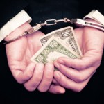 Businessman hands in handcuffs