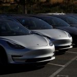 A row of new Tesla Model 3 electric vehicles is seen at a parking lot in Richmond, California